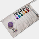 Set of colorful tuning forks in a canvas apron roll-bag with a Soma Energetics Logo on a white background. 