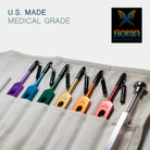 Set of colored tuning forks and tools in a canvas apron roll-bag with 'U.S. Made Medical Grade' text and Soma Energetics logo.